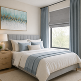 Misty blue cotton blend blackout curtains paired with a light gray Roman shade in a modern Scandinavian bedroom featuring white bedding, a gray upholstered bed, light wood furniture, and soft natural daylight.